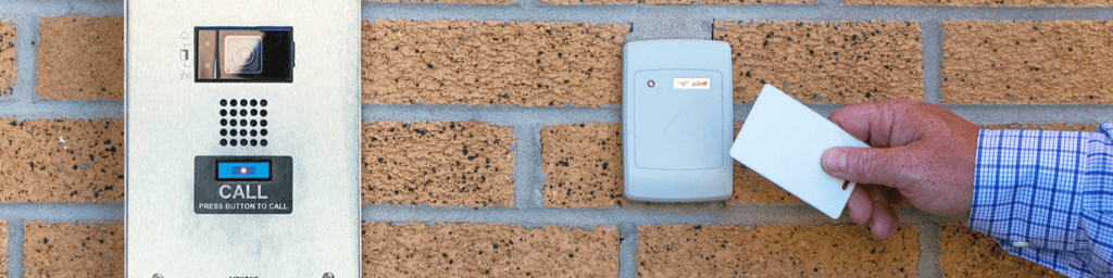 Man scanning in for work using his keycard, and an intercom to the left.