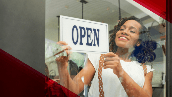 small business owner turning the sign in her window to say open.